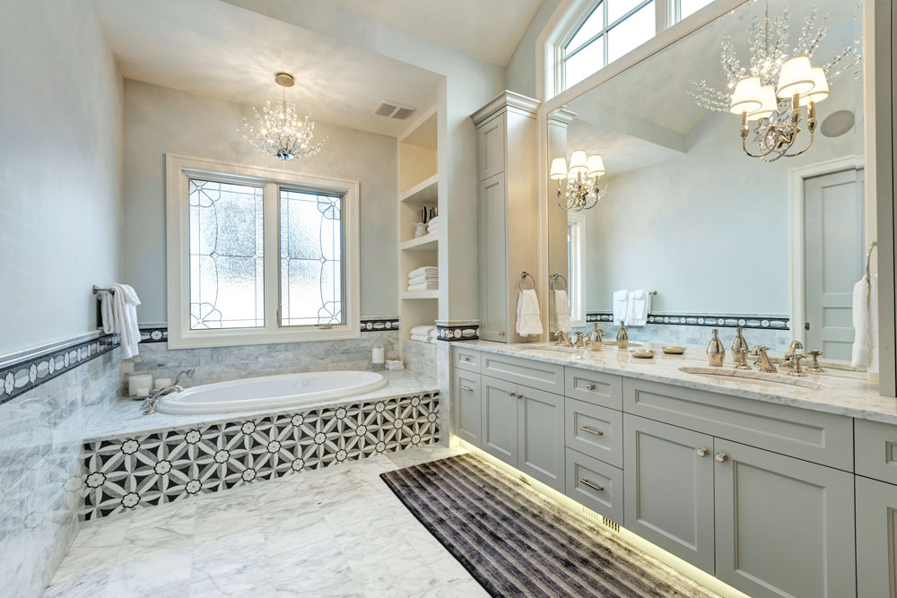 The principal bathroom is a spa-like retreat awash in a soothing palette of white and grey and intricate tile work.