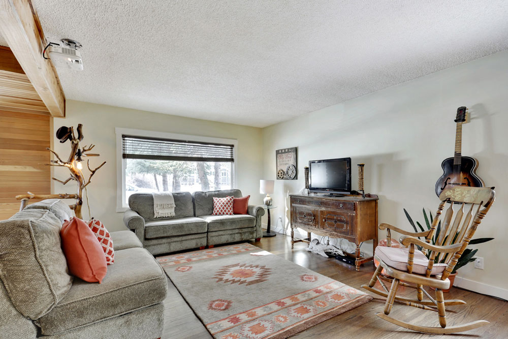 The living room has hardwood floors and a wood ceiling beam.