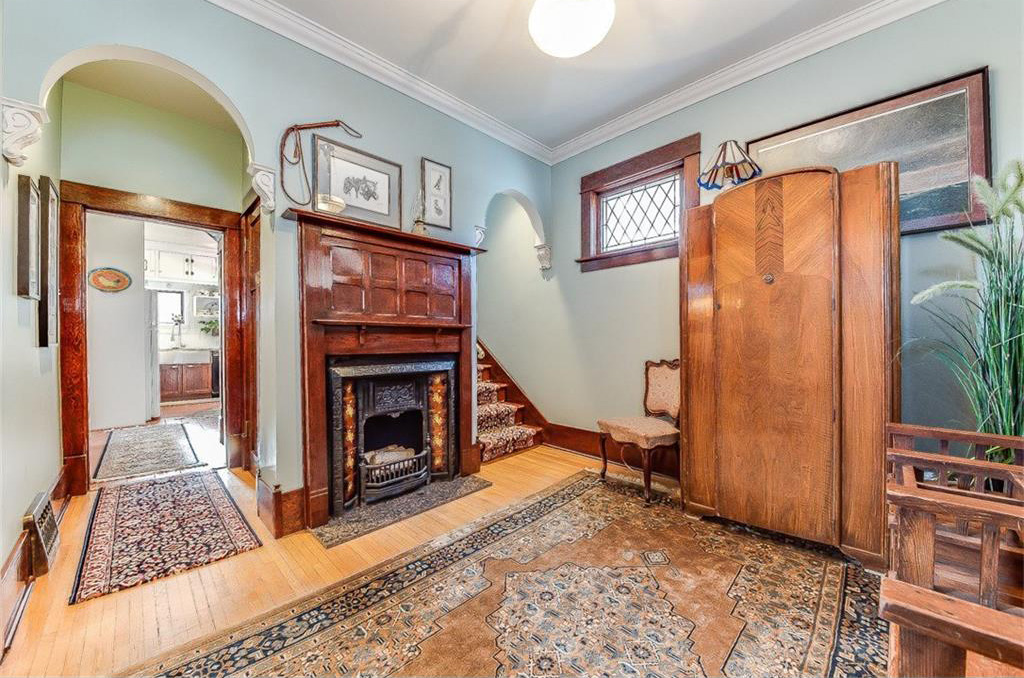 The entranceway has a fireplace with original woodwork and mantle.