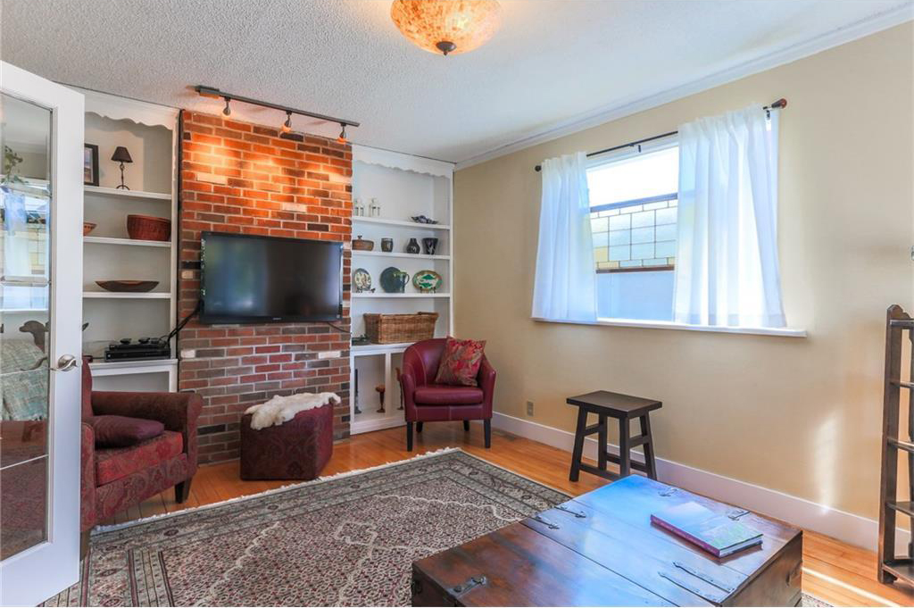 The living room has French doors, built-ins and stained glass accents in the window.