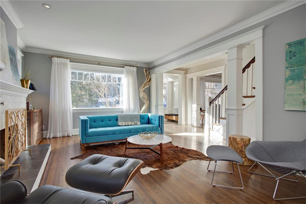 The sunny living room has original hardwood and an original wood burning fireplace.