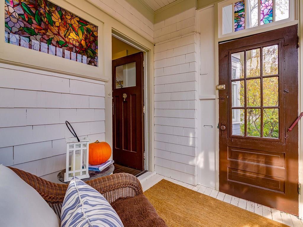 The enclosed front porch has striking stained glass windows.